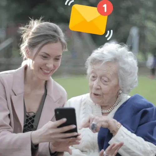 in a park, a woman is showing an older woman email on her phone
