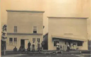 historic black and white photo of people in front of buildings on wooden sidewalks and stairs